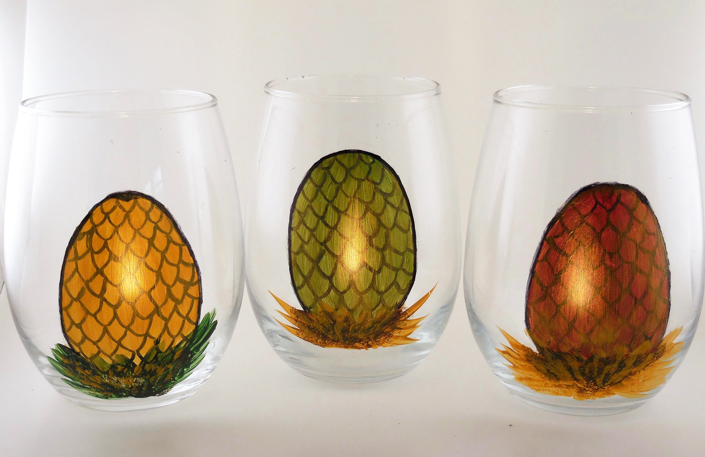 3 stemless wine glasses with dragon egg designs